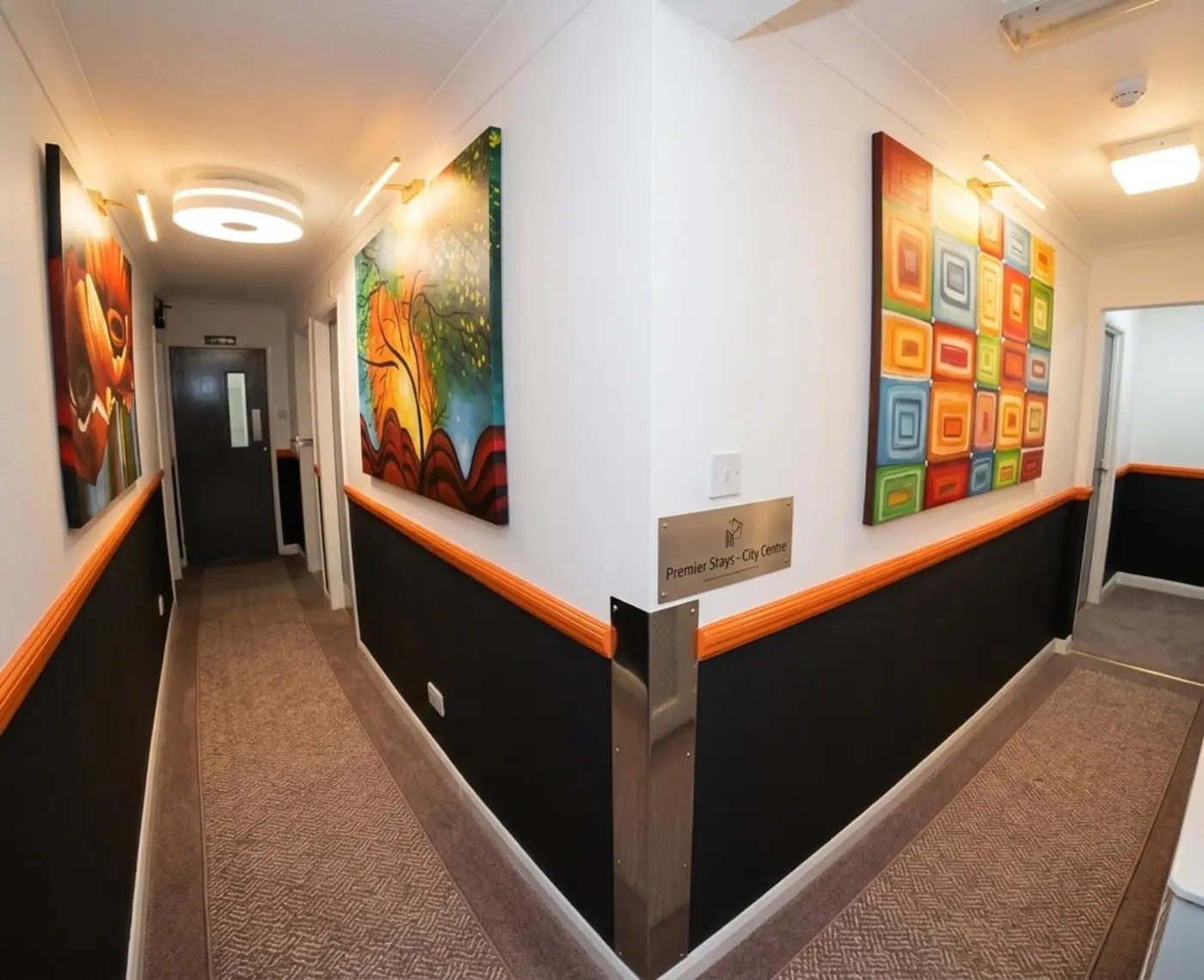 Bright hotel corridor at Heathrow Inn Hotel with artwork on the walls